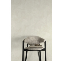 Židle s textilním potahem, knihami a miskou před stěnou