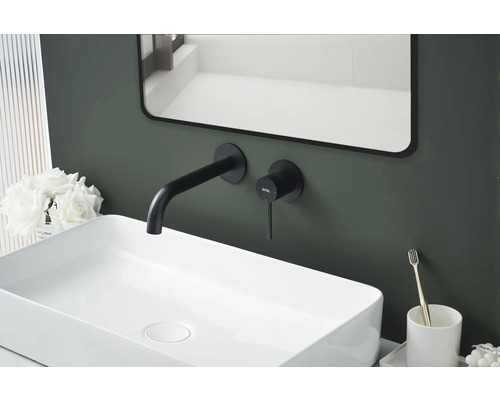 Detailní záběr umyvadla s baterií, zrcadlem a dekorativními prvky v koupelně