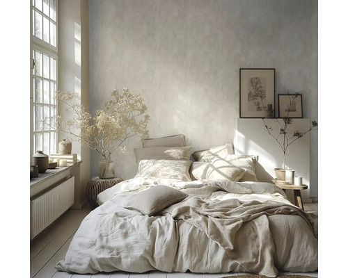 Světlá ložnice s postelí, polštáři, dekou, obrazy a dekoracemi