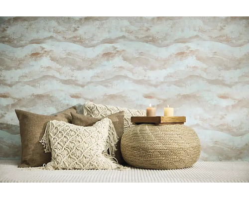 Obývací pokoj s vzorovanou tapetou, okrasnými polštáři a sedacím pufem