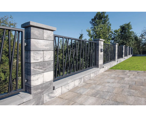 Pohled do zahrady s plotem z betonových bloků a kovových prvků