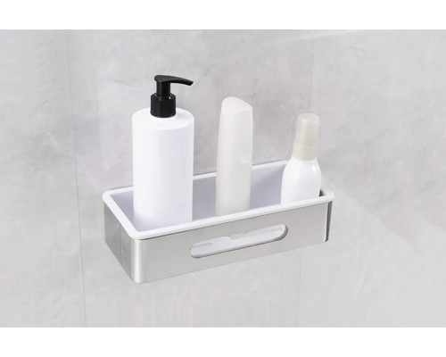 Sprchová polička s pleťovými vodami a kosmetickými produkty na zdi