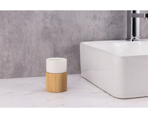 Kelímek na zubní kartáčky z keramiky a bambusu vedle umyvadla