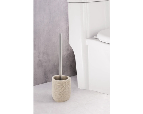 Toaletní kartáč s nádobou a nerezovou rukojetí vedle toalety