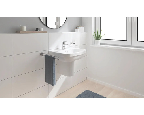 Moderní koupelna s umyvadlem, baterií, držákem na ručníky, zrcadlem a rostlinou