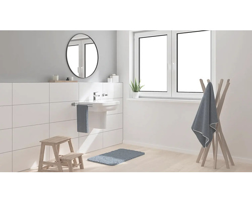 Moderní koupelna s umyvadlem, zrcadlem, držákem na ručníky, oknem a dřevěným regálem.