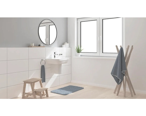 Koupelna s umyvadlem, zrcadlem, držákem na ručníky, stoličkou a oknem pro světlé a uspořádané prostředí.