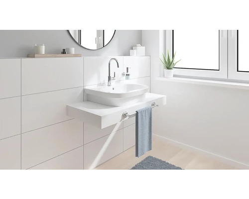 Moderní koupelna s umyvadlem na desku, baterií a držákem na ručníky před bílou obkládanou stěnou