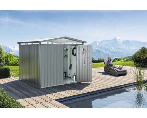 Kovová zahradní chatka s otevřenými dveřmi a nářadím na vnitřní straně dveří na dřevěné terase vedle bazénu