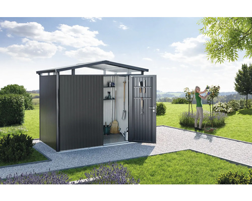 Otevřená kovová zahradní kůlna se zahradním nářadím a ženou pracující na zahradě.