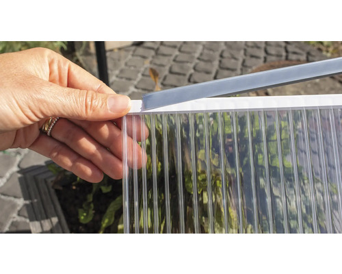 Osoba drží polykarbonátovou desku s profilem