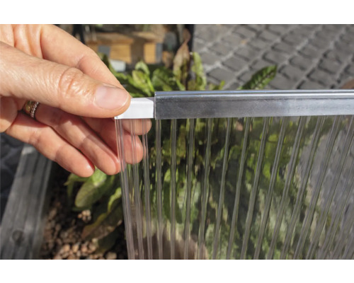 Ruka drží průhlednou polykarbonátovou desku s profilem