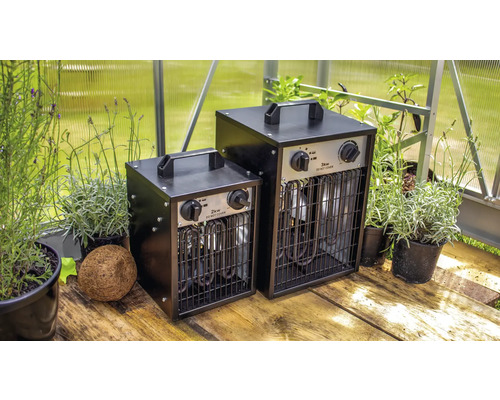 Dva skleníkové ohřívače s výkonem 2 kilowatty a 3 kilowatty vedle hrnkových rostlin