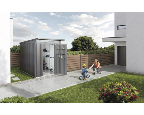 Zahradní skříň s otevřenými dveřmi, uvnitř zahradní nářadí a dětské hračky, na zahradě