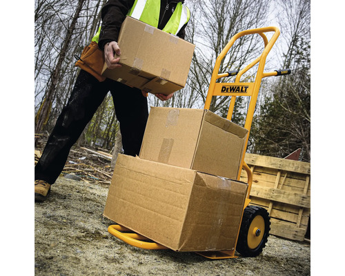 Žlutý rudl naložený kartony, obsluhovaný osobou s bezpečnostní vestou