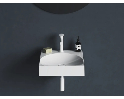 Moderní umyvadlo s baterií, mýdlem a dávkovačem na tmavé zdi