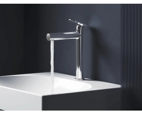 Lesklá chromová umyvadlová baterie s tekoucí vodou nad bílým umyvadlem