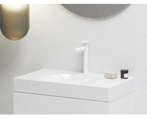 Moderní koupelna s bílým umyvadlem, baterií, mýdlem a kosmetickou dózou