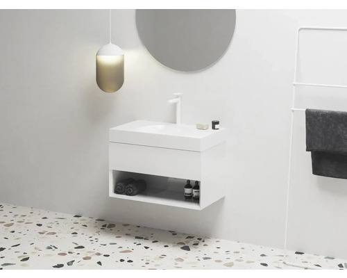 Moderní koupelna s bílou umyvadlovou skříňkou, kulatým zrcadlem a držákem na ručníky