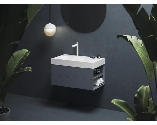 Moderní koupelna s umyvadlovou skříňkou, umyvadlem na desku, baterií, kulatým zrcadlem a závěsným svítidlem.