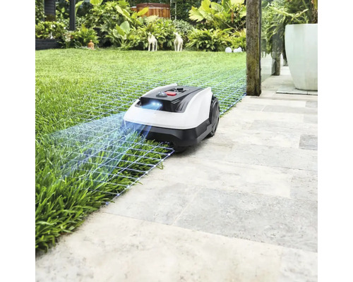 Robotická sekačka na trávníku a kamenných deskách v zahradě