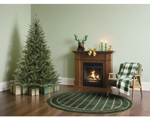 Obývací pokoj s vánočním stromkem, krbem a křeslem pro sváteční atmosféru