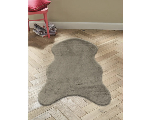 Šedý koberec se vzhledem kožešiny na dřevěné podlaze