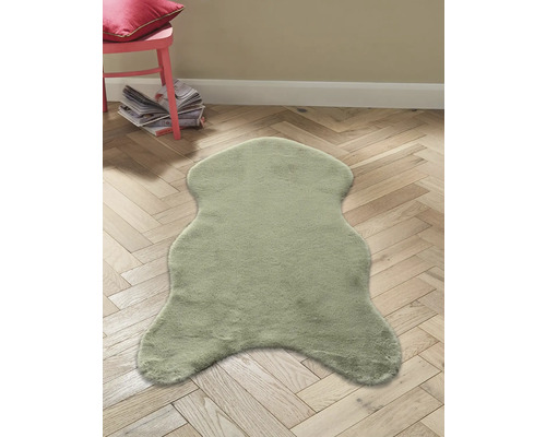 Dekorační kožešina na dřevěné podlaze se židlí a časopisy v pozadí