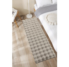 Dekorativní ložnice s postelí, židlí a obdélníkovým kobercem