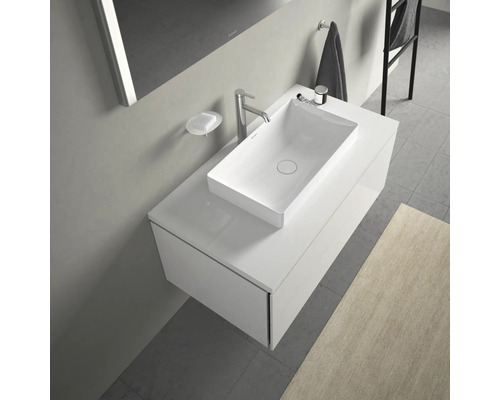 Moderní koupelnové umyvadlo se skříňkou, baterií a miskou na mýdlo.