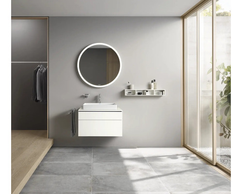 Moderní koupelna s umyvadlem, zrcadlem s osvětlením a policemi.