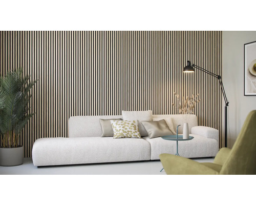 Obývací pokoj s dřevěným obkladem stěn, pohovkou, stojací lampou a pokojovou rostlinou.