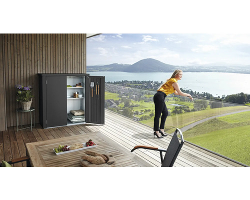 Scéna s úložnou skříní s otevřenými dveřmi na terase s výhledem na jezero