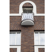 Fasáda cihlové budovy s oknem a balkonem