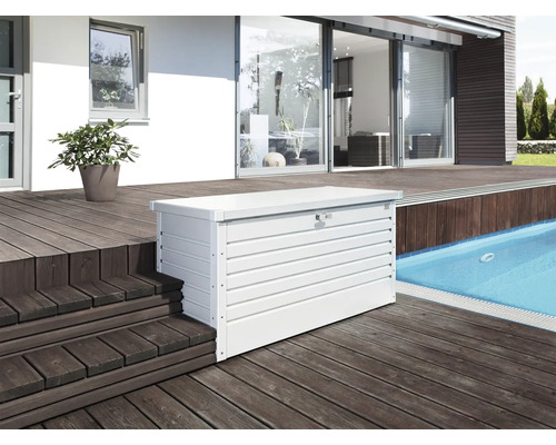 Snímek bílého kovového boxu na nářadí na dřevěné terase venku.