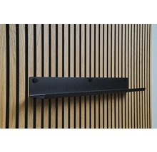 Černá nástěnná police na dřevěné stěně