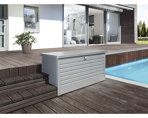 Zahradní box na polstry Biohort 160 High 159 x 79 x 83 cm stříbrný metalický Snímek šedé kovové úložné skříně na dřevěné terase vedle bazénu.