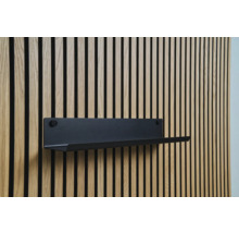 Černá nástěnná police na dřevěné obkladové stěně