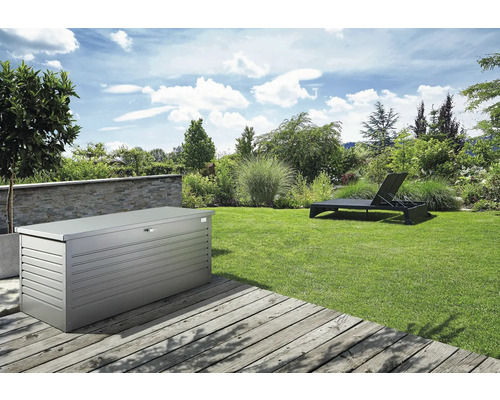 Zahradní krajina s kovovým úložným boxem a lehátkem na trávníku