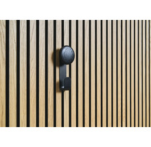 Dřevěný obklad s černým háčkem na šaty