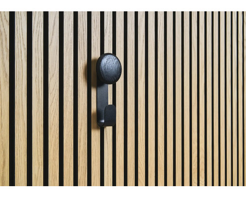 Dřevěný obklad s černým háčkem na šaty