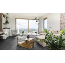 Obývací pokoj s pohovkou, křeslem, stolem a dřevěnou truhlou na tmavé podlaze