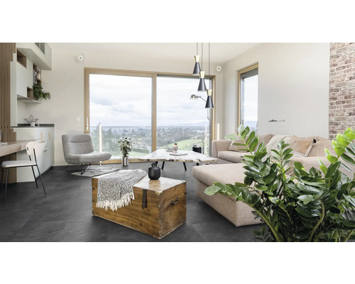 Obývací pokoj s pohovkou, křeslem, stolem a dřevěnou truhlou na tmavé podlaze