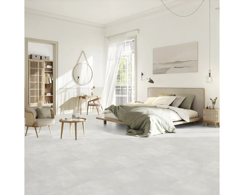 Světlá ložnice s postelí, posezením, skříní a dekoracemi na světlé podlaze