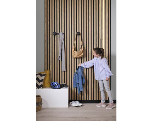 Chodba s dřevěnou lamelovou stěnou, háčky na šaty a dítě