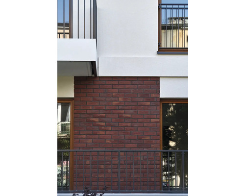 Fasáda budovy s červeným cihlovým zdivem a balkony