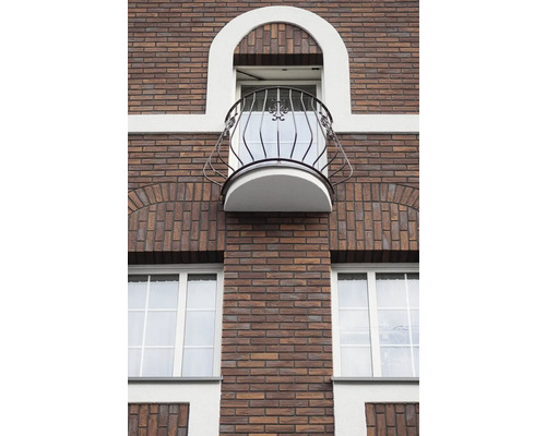 Fasáda budovy s cihlovým zdivem, okny a balkonem