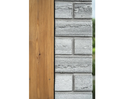Detailní pohled na fasádu s dřevěným obkladem a zdivem