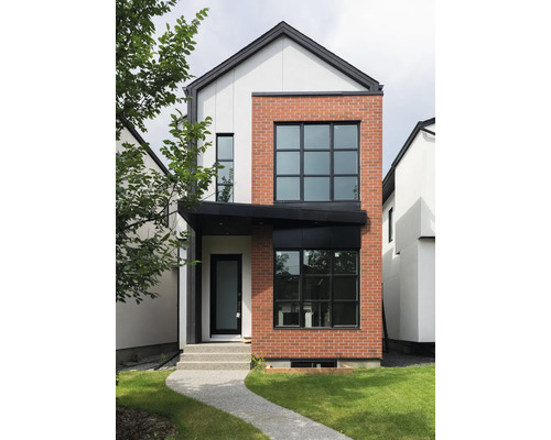 Pohled na moderní dvoupodlažní dům s fasádou z cihel a omítky