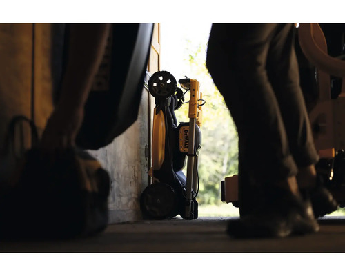 Složený pracovní světlomet DeWalt s transportními kolečky, uložený v dílně